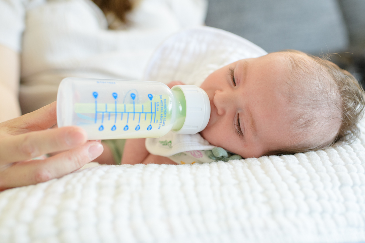Newborn drinking a bottle during a indoor newborn lifestyle session with Salt Lake photographer Jodi Cornwall Photography