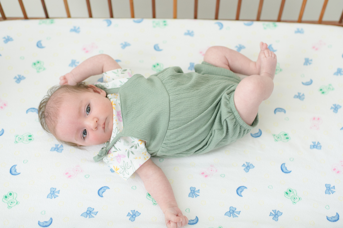 Newborn baby laying in bassinet during lifestyle photo session.
