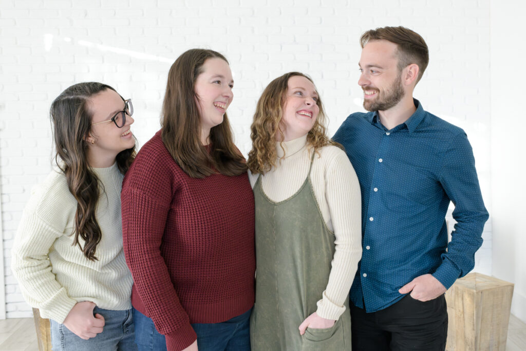 Adult siblings smiling at each other during an extended family session with Jodi Cornwall Photography.